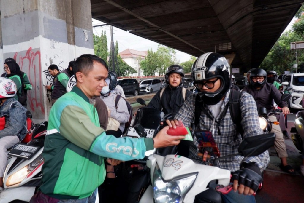 Mitra Pengemudi Grab membagikan takjil kepada pengguna jalan yang melintas di kawasan Pasir Kaliki (Paskal).